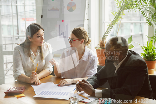 Image of Group of young business professionals having a meeting, creative office