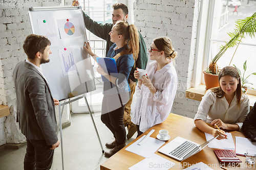 Image of Group of young business professionals having a meeting, creative office