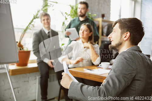 Image of Group of young business professionals having a meeting, creative office