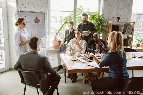 Image of Group of young business professionals having a meeting, creative office