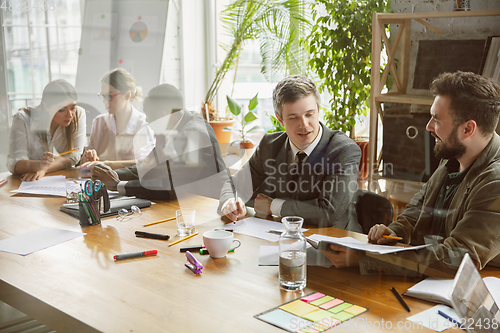 Image of Group of young business professionals having a meeting, creative office