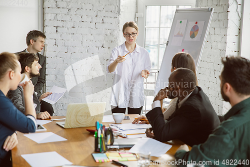 Image of Group of young business professionals having a meeting, creative office