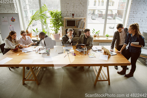 Image of Group of young business professionals having a meeting, creative office