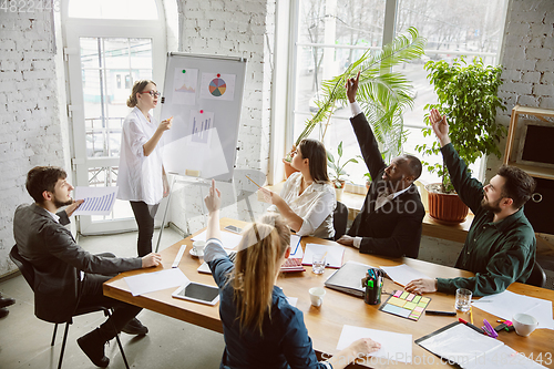 Image of Group of young business professionals having a meeting, creative office