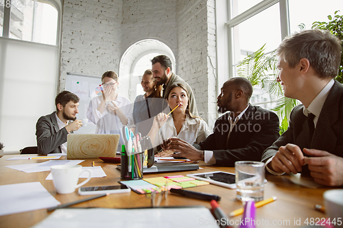 Image of Group of young business professionals having a meeting, creative office