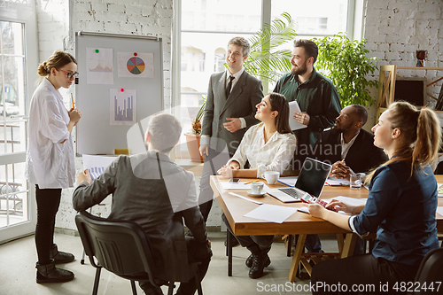 Image of Group of young business professionals having a meeting, creative office