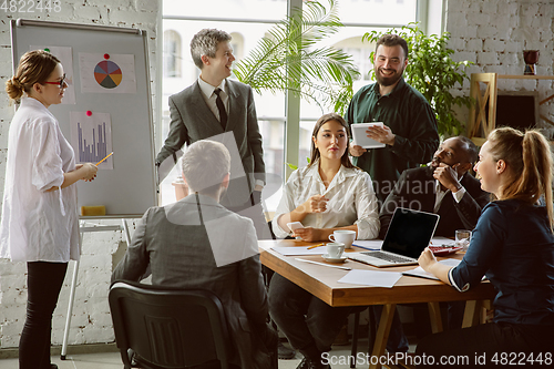 Image of Group of young business professionals having a meeting, creative office