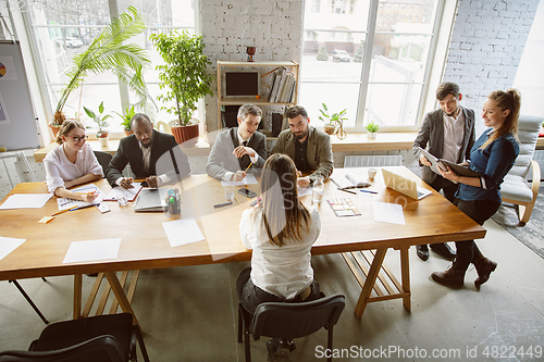 Image of Group of young business professionals having a meeting, creative office