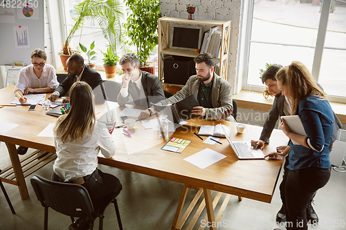 Image of Group of young business professionals having a meeting, creative office