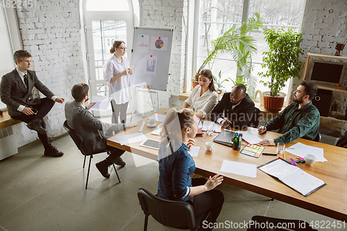 Image of Group of young business professionals having a meeting, creative office