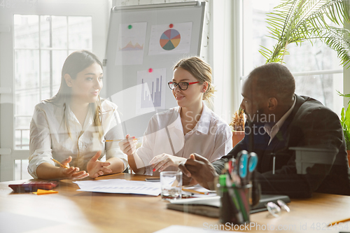 Image of Group of young business professionals having a meeting, creative office
