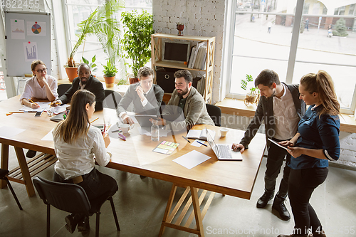 Image of Group of young business professionals having a meeting, creative office