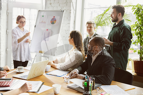 Image of Group of young business professionals having a meeting, creative office