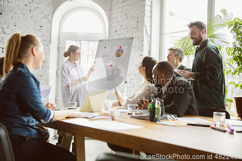 Image of Group of young business professionals having a meeting, creative office