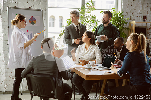 Image of Group of young business professionals having a meeting, creative office