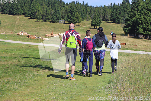 Image of Family with children hiking outdoors in summer nature