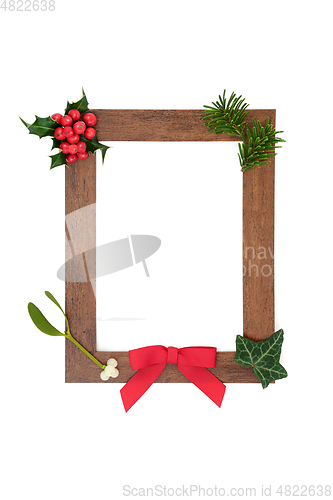 Image of Wooden Frame with Winter Greenery Decoration 