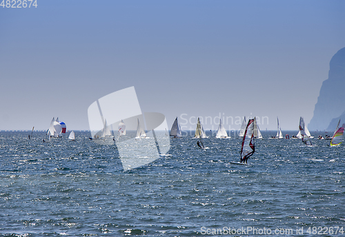 Image of Windsurfer surfing and sailboats sailing the wind on waves In la
