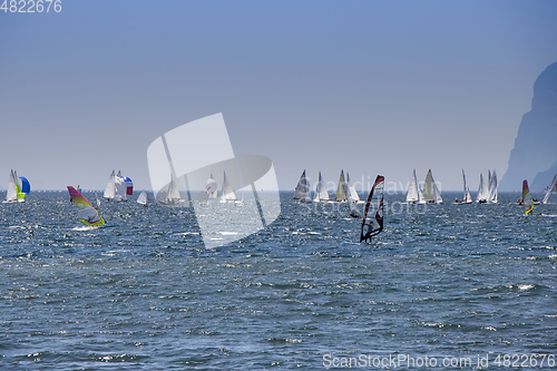 Image of Windsurfer surfing and sailboats sailing the wind on waves In la