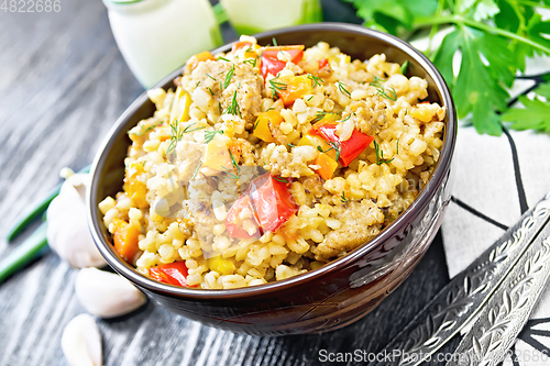 Image of Barley porridge with minced meat in bowl on wooden board