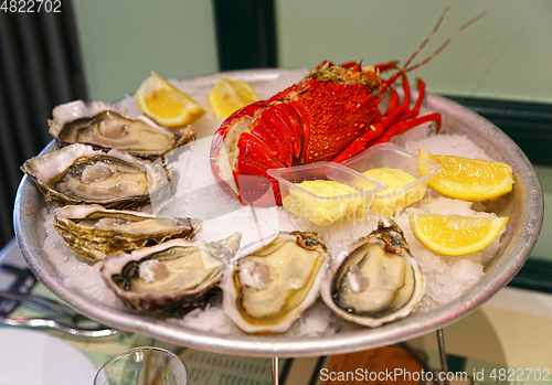 Image of Large dish with fresh seafood, oysters with lobster with lemon a