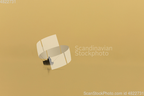 Image of fisherman silhouette on a foggy morning