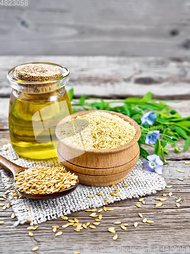 Image of Bran flaxseed in bowl with oil in jar on board