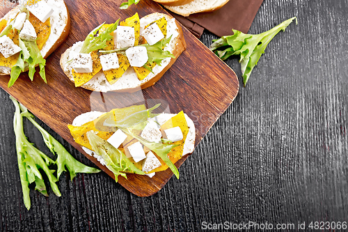 Image of Bruschetta with pumpkin and arugula on board top