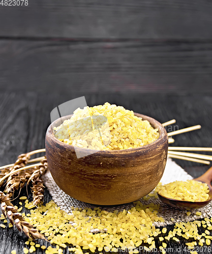 Image of Bulgur in bowl on wooden board