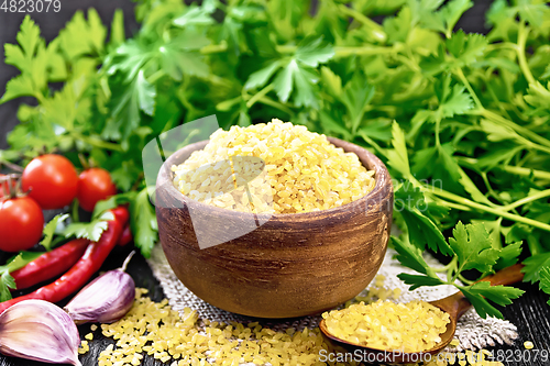 Image of Bulgur in bowl with vegetables on black board