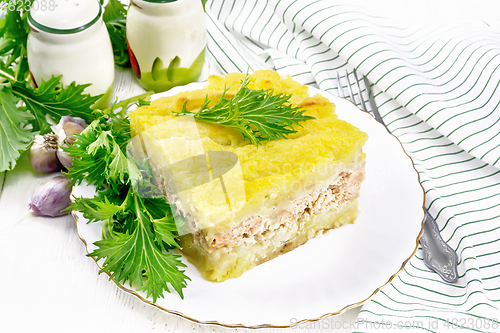 Image of Casserole with potatoes and fish in plate on white board