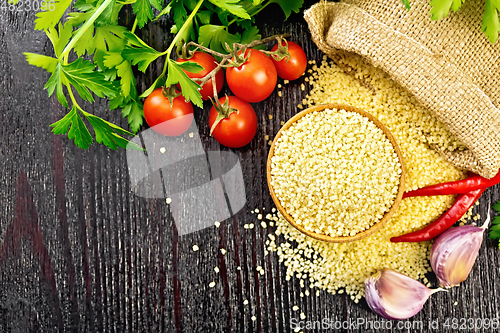 Image of Couscous raw in bowl on black board top