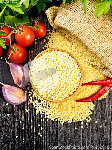 Image of Couscous raw in bowl on dark board top