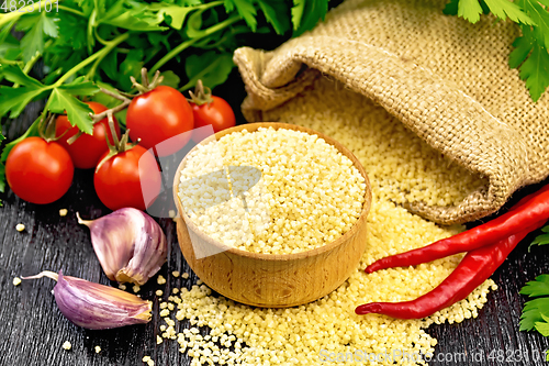 Image of Couscous raw in bowl on dark board