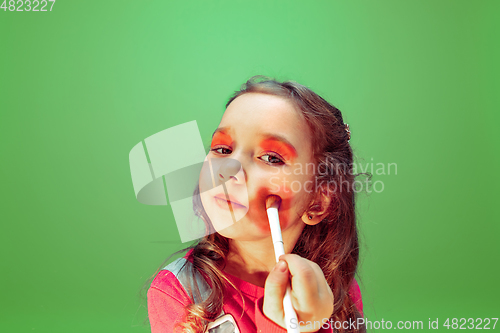 Image of Little girl dreaming about future profession of makeup and hairstyle artist