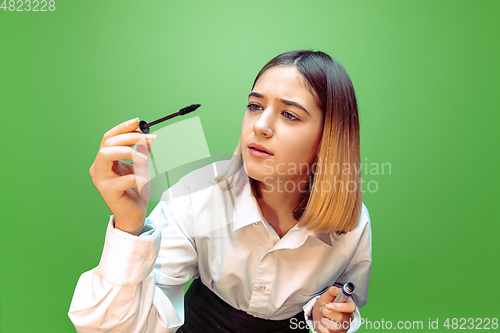 Image of Little girl dreaming about future profession of makeup and hairstyle artist