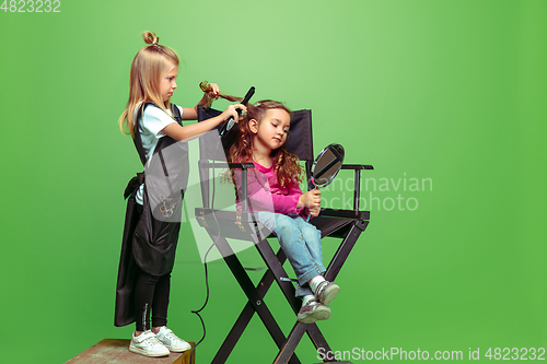 Image of Little girl dreaming about future profession of visage and hairstyle artist