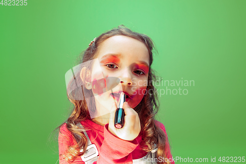 Image of Little girl dreaming about future profession of makeup and hairstyle artist