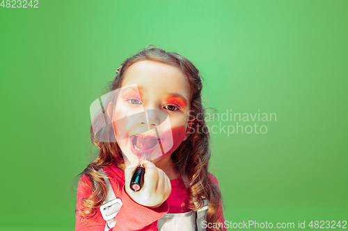 Image of Little girl dreaming about future profession of makeup and hairstyle artist