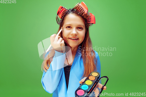 Image of Little girl dreaming about future profession of makeup and hairstyle artist