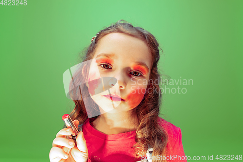 Image of Little girl dreaming about future profession of makeup and hairstyle artist