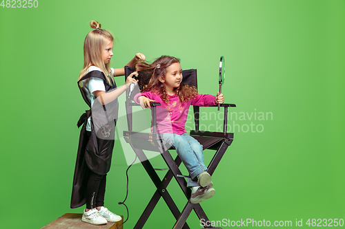 Image of Little girl dreaming about future profession of visage and hairstyle artist