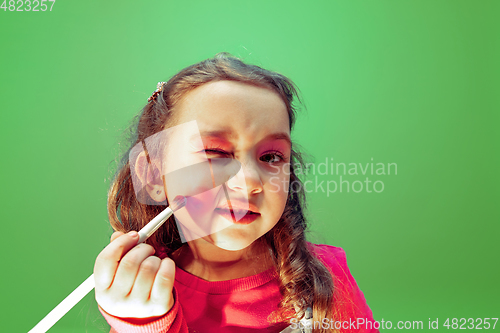 Image of Little girl dreaming about future profession of makeup and hairstyle artist