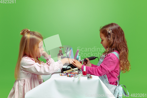 Image of Little girl dreaming about future profession of nails manicure artist