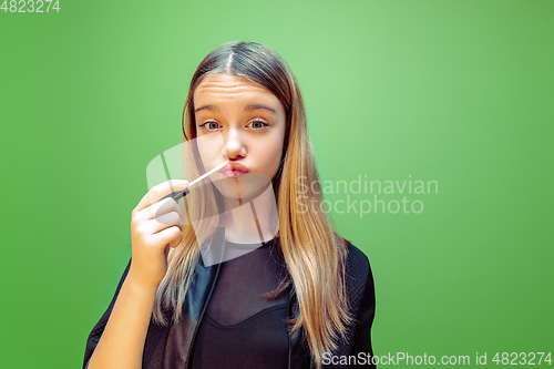 Image of Little girl dreaming about future profession of makeup and hairstyle artist