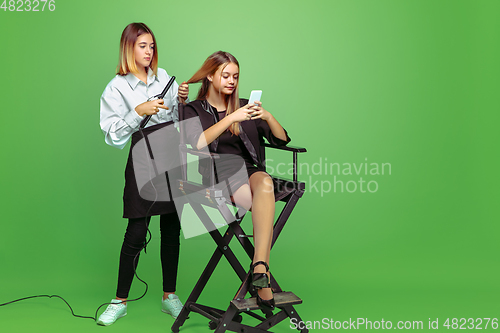 Image of Little girl dreaming about future profession of visage and hairstyle artist