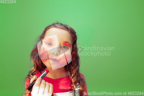 Image of Little girl dreaming about future profession of makeup and hairstyle artist