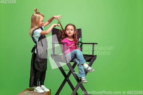 Image of Little girl dreaming about future profession of visage and hairstyle artist