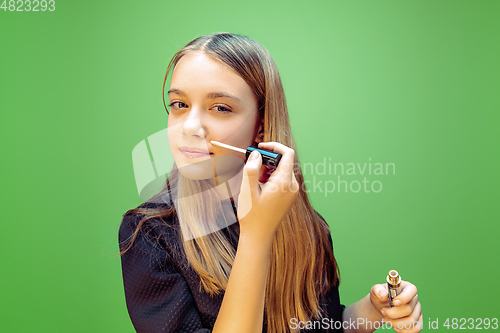 Image of Little girl dreaming about future profession of makeup and hairstyle artist