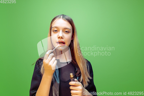 Image of Little girl dreaming about future profession of makeup and hairstyle artist